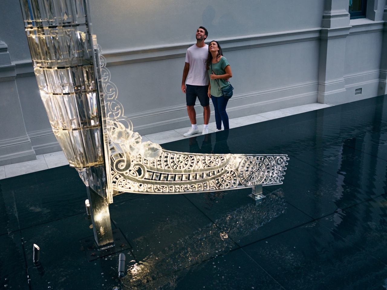 A couple observe the Crystal Waka at Auckland Art Gallery