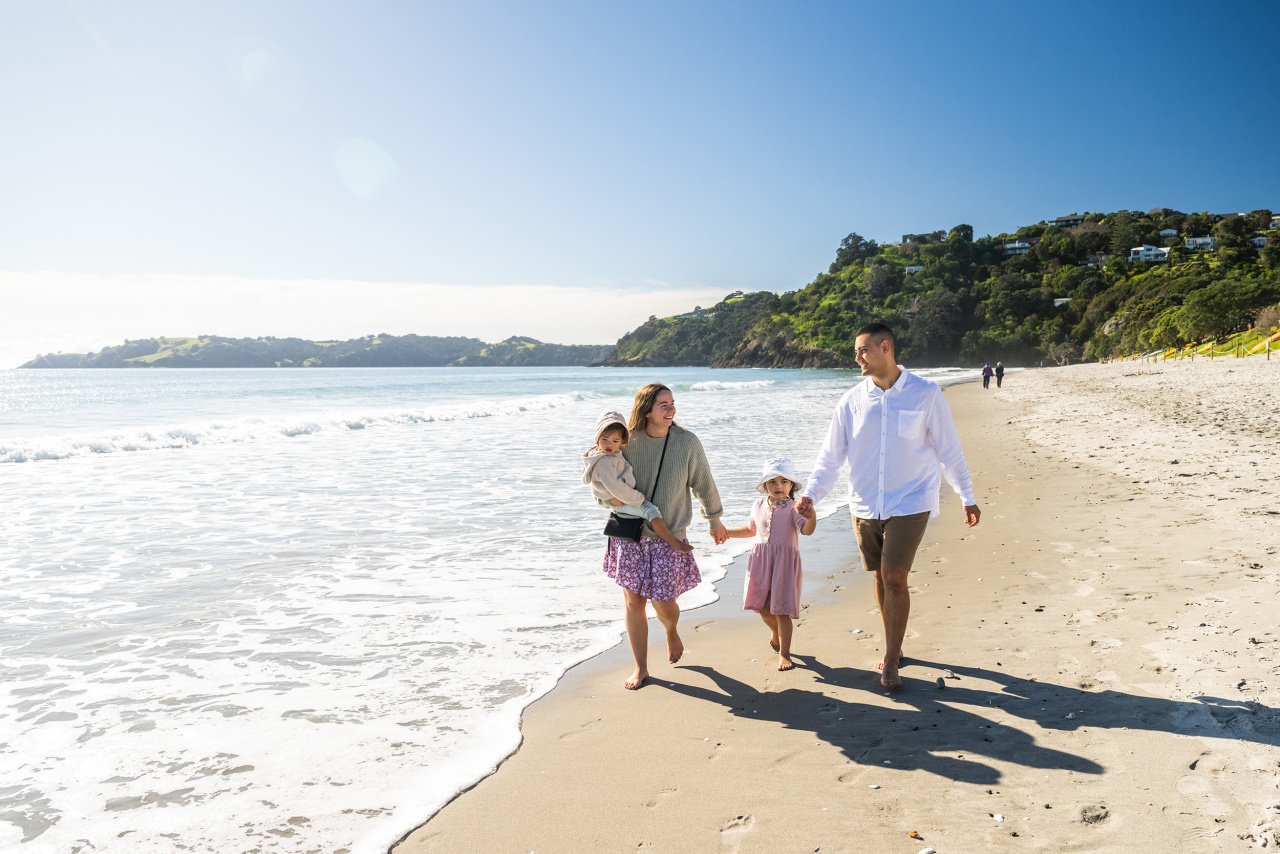 Family walking on Onetangi Beach in Waiheke Island