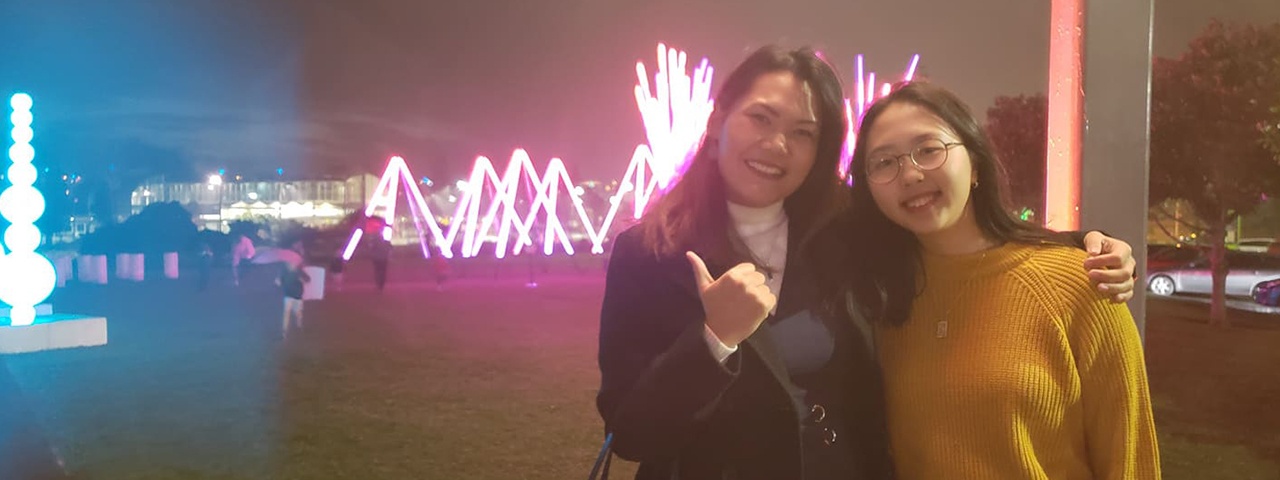 Jhe Valenzuela and Sonia Min in front of a light display at Stellar - Festival of Lights, part of Elemental AKL 2019