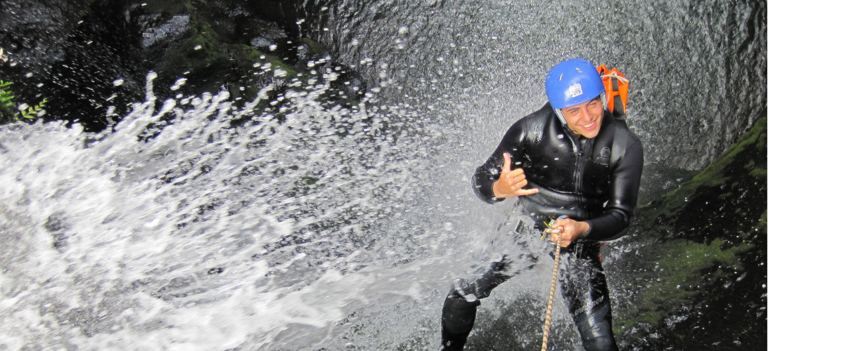 Person having fun climbing a waterfall