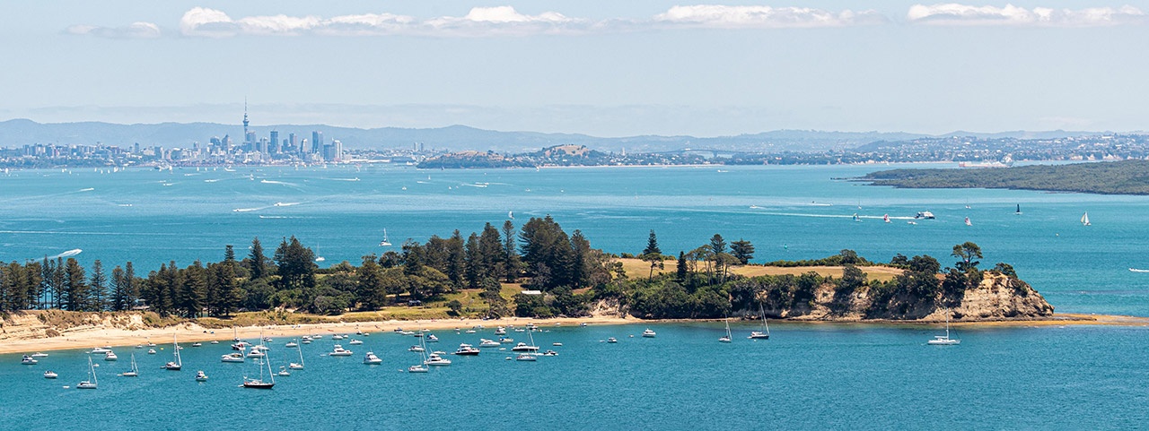 Motuihe Island with boats in the harbour and Auckland city in the background