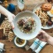 A table full of food and someone passing a plate to someone else